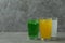 Glasses of different soda on gray background