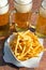 Glasses of draft beer and french fries on the plate