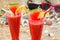 Glasses with fresh watermelon juices on sandy beach