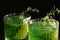 Glasses of homemade refreshing tarragon drink on black background, closeup