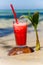 Glasses with juice stands on a fallen coconut.