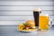 Glasses of light and dark beer with cheeseburger and French fries on aluminum panels