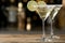 Glasses of Lime Drop Martini cocktail on wooden table against blurred background