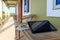 Glasses, newspaper and laptop on wooden table in motel balcony