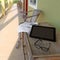 Glasses, newspaper and laptop on wooden table in motel balcony