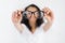 Glasses optician showing eyewear. Closeup of glasses, with glasses and frame in focus. Woman holding and pointed glasses on white