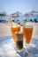 Glasses with orange juice and frappe on a table in the traditional greek tavern.