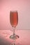 Glasses with red wine on a background reflection, pink background