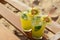 Glasses of refreshing drink with kiwi and mint on wooden bench at beach