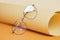 glasses on rolled beige paper, geometric background, trending colors, yellow background