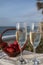 Glasses of Spanish cava sparkling wine with fresh ripe strawberry and view on blue sea and sandy beach, Costa del Sol vacation