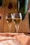 Glasses of sparkling white wine champagne or cava with bubbles and classic wooden champagne pupitre rack with empty bottles on
