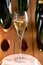 Glasses of sparkling white wine champagne or cava with bubbles and classic wooden champagne pupitre rack with empty bottles on