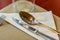 Glasses, spoon, frog, knife, napkin and plates on table setting