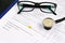 Glasses, stethoscope and yellow pill on medical questionnaire form