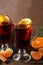 Glasses of tasty mulled wine with orange on wooden background