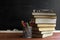 Glasses teacher books and a stand with pencils on the table, on the background of a blackboard with chalk. The concept of the teac