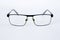 Glasses for the visually impaired, poorly sighted.glasses with aspherical astigmatic lenses  in black frame on a white background.