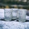 Glasses of vodka standing on frosty table outdoors