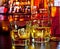 Glasses of whiskey with ice on bar table near whiskey bottle on warm atmosphere