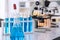 Glassware with blue liquid and equipment in chemistry science laboratory, science and medical research and development concept