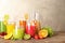 Glassware with different juices and fresh fruits on table