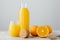 Glassware of fresh orange juice, ripe fruit and wooden squeezer against white background. Slice of orange. Squeezed organic drink