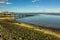 Glassy water at the shoreline with the longest pleasure pier in the world in the distance at Southend-on-Sea, UK