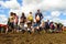 Glastonbury Festival crowds walk through mud beneath sunny sky