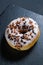 Glazed brown donut on shale dishes and black wooden background