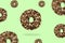 Glazed brown sweet sugar chocolate doughnut donut dessert on gradient green pastel background. Creative minimal blurred