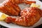 Glazed chicken leg quarters with sesame seeds and lemon close-up. horizontal