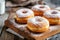 Glazed Doughnuts Sprinkled With Powdered Sugar on a Wooden Board