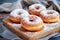 Glazed Doughnuts Sprinkled With Powdered Sugar on a Wooden Board