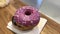 Glazed pink donut with chocolate on wooden table