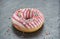 Glazed round donut with sprinkles on a stone table