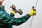 Glazier holding in his hands a piece of thick glass with the help of a special suction cup, Light background