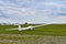 Glider plane standing on grass airport runway with dramatic sky background