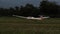 Glider, sailplane, landing in the dark after sunset on a grass airfield