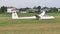 Glider slows and stops after landing in grass runway and a church in background