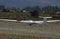 Glider ultralight plane flying near mountains, landing on earth aerodrome