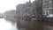 Glimpse of amsterdam river, on a cold and gray autumn day. the boats rest still and sleepy along the canal and everything seems to