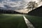 glimpse of Lucca walls with lawn and ditch with water at dawn