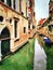 A glimpse of the small canals with boats between the historic buildings in the center of Venice