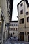 Glimpse of a street in Florence with historic building and shop.