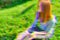Glitch effect Young beautiful girl drinking coffee in the Park sitting on the grass Banner copy space