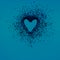 Glitter heart dissolving into pieces on blue background. Valentines day, broken heart and love concept