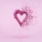 Glitter heart dissolving into pieces on pink background. Valentines day, broken heart and love emergence concept