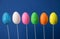 Glittering Easter eggs of different colors on blue background.