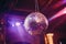 glittery disco ball hanging from the ceiling of a ballroom